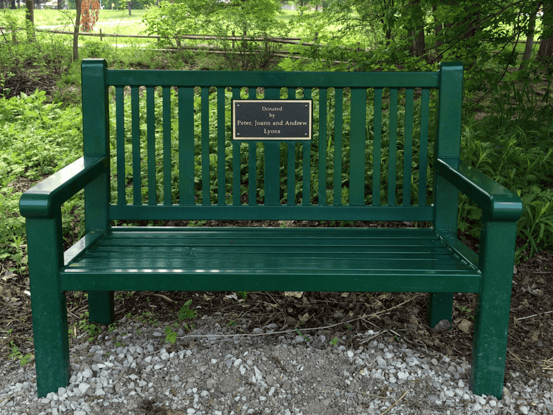 A dark green bench donated by Peter, Joann and Andrew Lyons