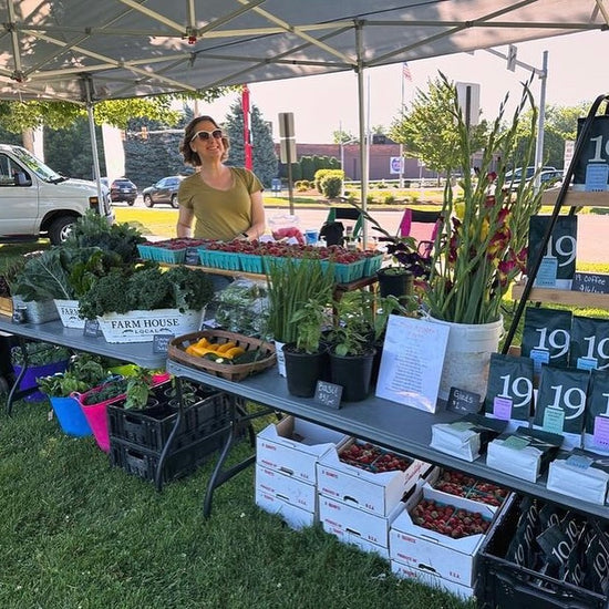 A women standing in front of her stand called "Farm House" during the Open market event