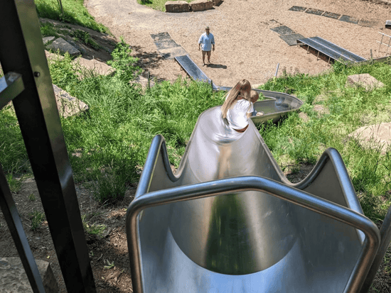 A girl and her little sibling going down one of the Griff Slides